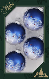 This image shows the KREBS packaging that this set of four ornaments comes in. The four ornaments are round and are navy blue on top and its ombres into white. They each feature white trees and rede cardinals.
