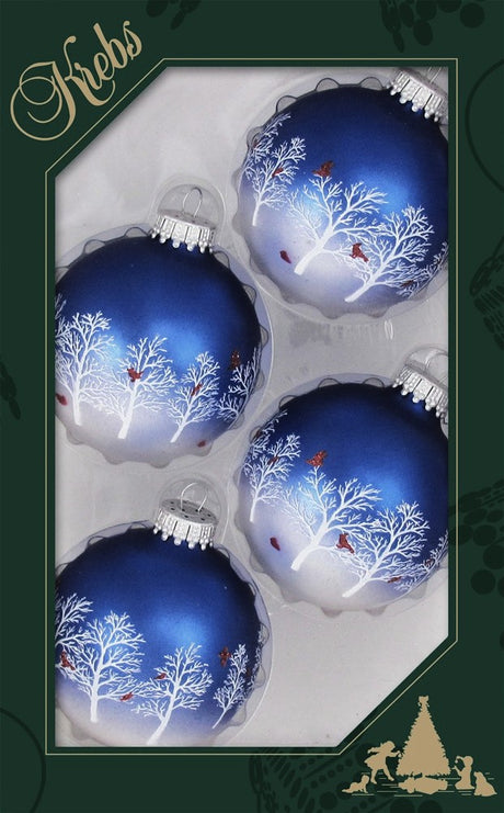 This image shows the KREBS packaging that this set of four ornaments comes in. The four ornaments are round and are navy blue on top and its ombres into white. They each feature white trees and rede cardinals.