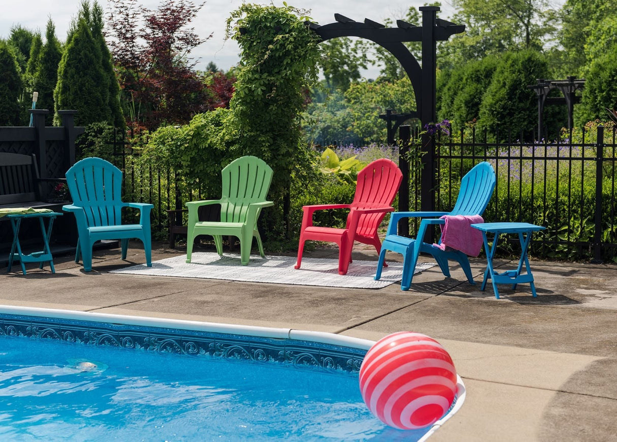 Adirondack chairs near the edge of a pool.