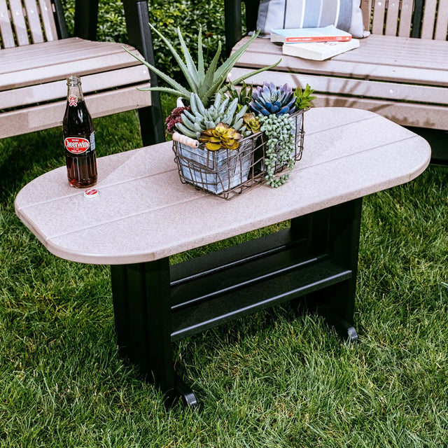This is a lifestyle image showing the Weatherwood and Black colored coffee table in front of two Weatherwood and Black colored benches.
