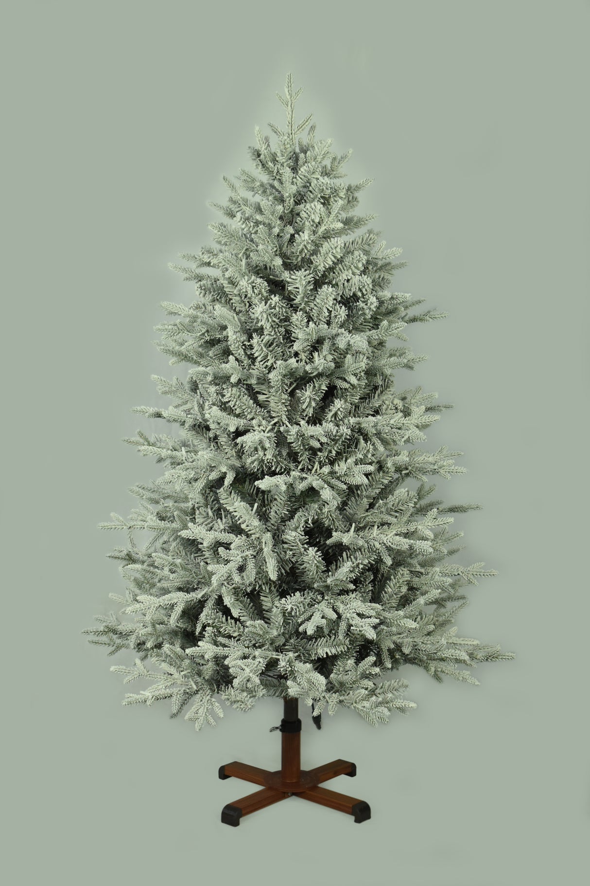 This image shows the flocked Christmas tree with the lights turned off. The tree is up against a light gray background.
