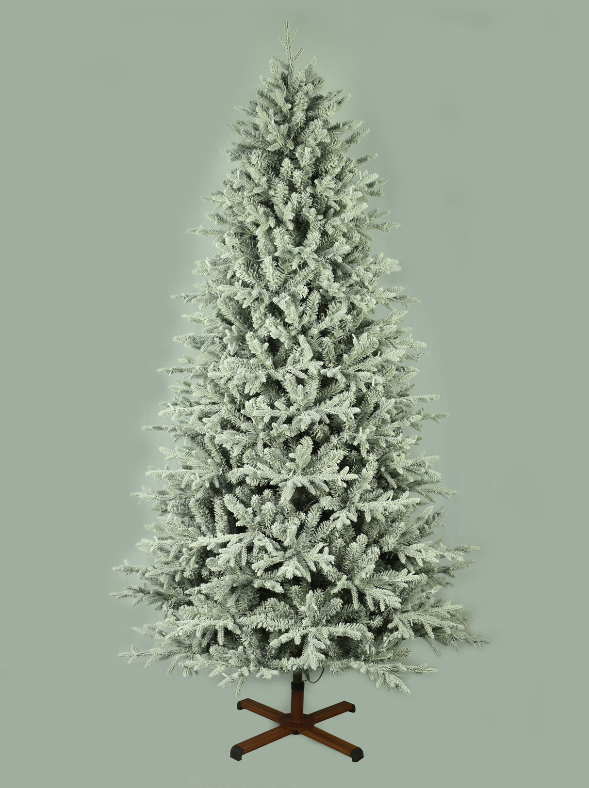 This image shows the flocked Christmas tree with the lights turned off. The tree is up against a light gray background.