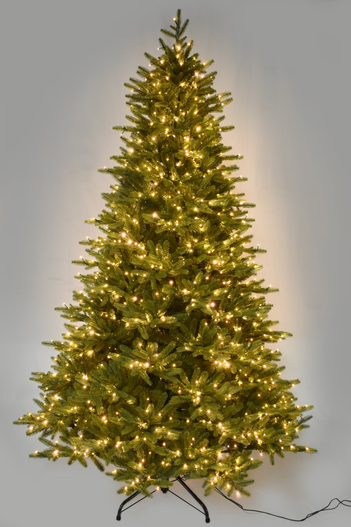 Artificial tree pre-lit with warm white starry LED lights.