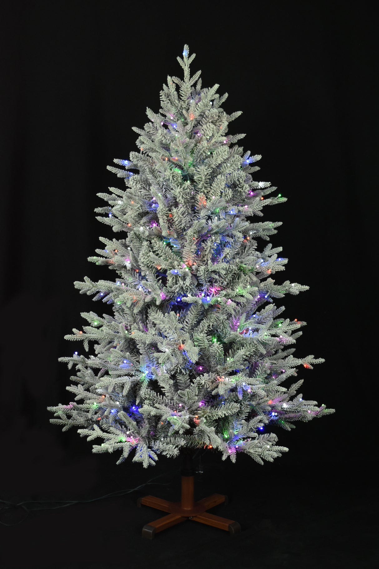 This image shows the flocked Christmas tree pre-lit with Multi-Colored Starry Lights. The tree is up against a black background.