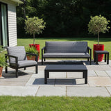 This is a lifestyle image showing this patio furniture set on a stone patio in a grassy backyard.