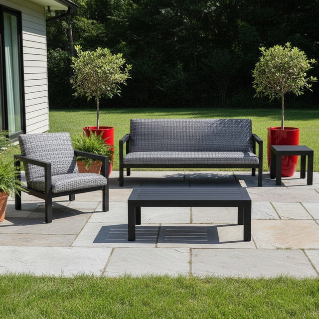 This is a lifestyle image showing this patio furniture set on a stone patio in a grassy backyard.