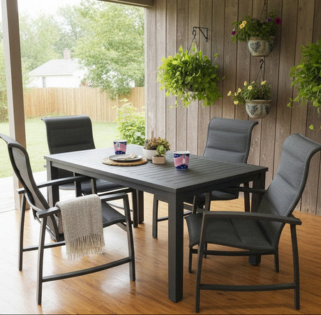 This is a lifestyle image showing this patio dining set on a covered wooden porch on a sunny day. There are hanging potted plants on the wall.
