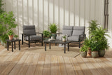 This is a lifestyle image showing this patio set on a wooden deck surrounded by potted plants.