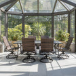This is a lifestyle image showing this outdoor dining set with woven sling backs in a solarium on a sunny day.