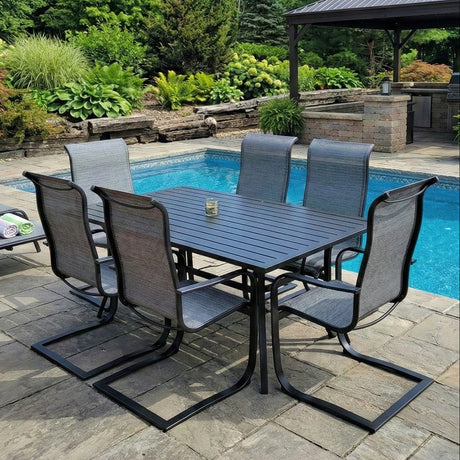 This is a lifestyle image showing this patio dining set on a stone patio next to an in-ground pool.