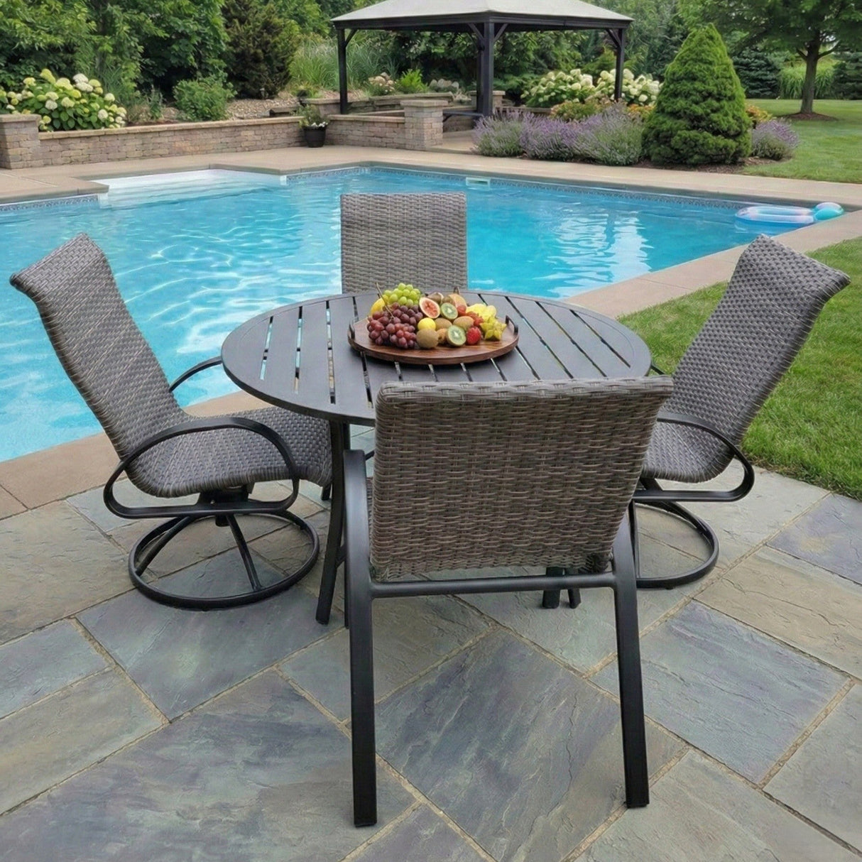 This is a lifestyle image showing this patio furniture set on a stone patio next to an in-ground pool.