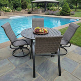 This is a lifestyle image showing this patio furniture set on a stone patio next to an in-ground pool.