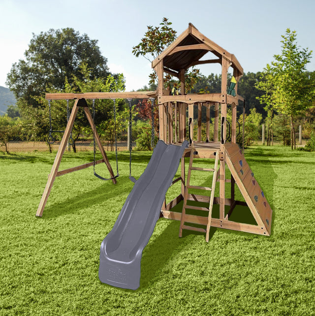 Wooden backyard playset in a sunny backyard. It features a 9‘ Double Wall Wave Slide, a durable Wooden Roof, a Rockwall, a Trapeze Bar with Rings, 2 Belt Swings, a 2-Position Swing Beam and a Wooden Entry Ladder with Handles.
