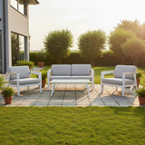 This is a lifestyle image showing the patio furniture set on a stone patio in a grassy backyard on a sunny day.