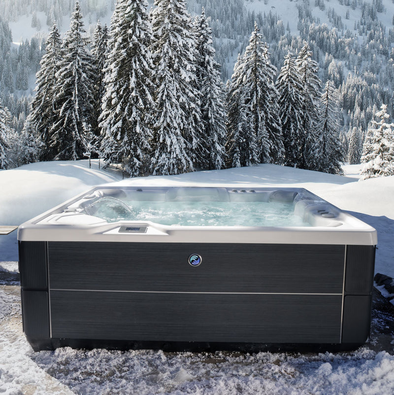 Hot Spring Grandee hot tub in a snowy landscape with trees