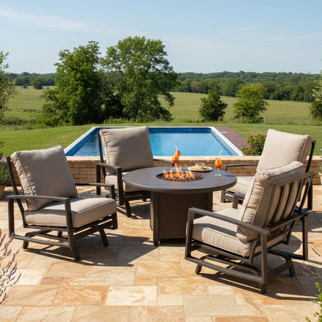 This is a lifestyle image showing this cushioned patio furniture set on a stone patio next to an in-ground pool in a grassy backyard.