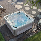 This is a lifestyle image showing the Inspire hot tub on a stone patio, taken from above.