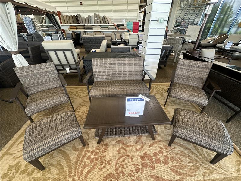 Clearance outdoor patio wicker chairs with textured patterned cushions on a yellow outdoor rug.