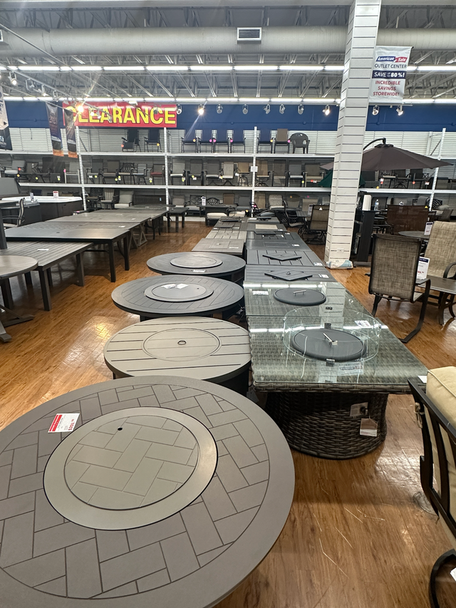 Outdoor fire pit tables display with chairs and tables in the Tinley Park Outlet store.