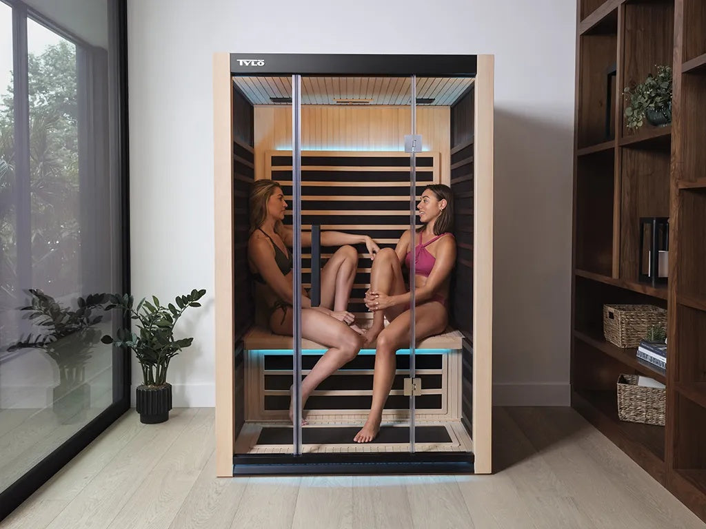 This is a lifestyle image showing two people sitting inside the sauna.