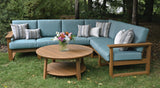 This is a lifestyle image showing the deep seating sectional set in a grassy backyard. The frames are antique mahogany and the cushions are cast breeze.