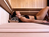 This is a lifestyle image showing a woman laying down inside the sauna.