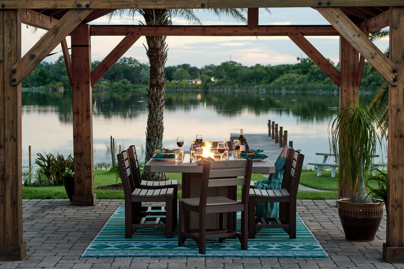 Outdoor dining setup under a wooden pergola by a lake