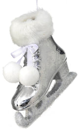 Silver ornament shaped like an ice skate. The cuff of the skate and the skate itself are furry and there are two pom poms tied to it.