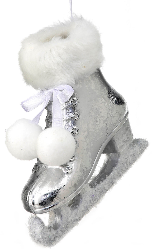 Silver ornament shaped like an ice skate. The cuff of the skate and the skate itself are furry and there are two pom poms tied to it.