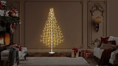 This animated image shows the birch wall tree up against a wall in a living room decorated for Christmas. The lights are twinkling.