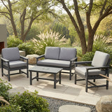 This is a lifestyle image showing this cushioned patio furniture collection on a stone patio in a grassy backyard on a sunny day.