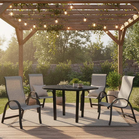 This is a lifestyle image showing this patio dining set on a wooden deck underneath a wooden pergola. The pergola has hanging lights and vines on it. The hexagon table has a coffee cup and a potted succulent on it.