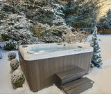 This is a lifestyle image showing this specific hot tub in a snowy, Midwestern backyard.