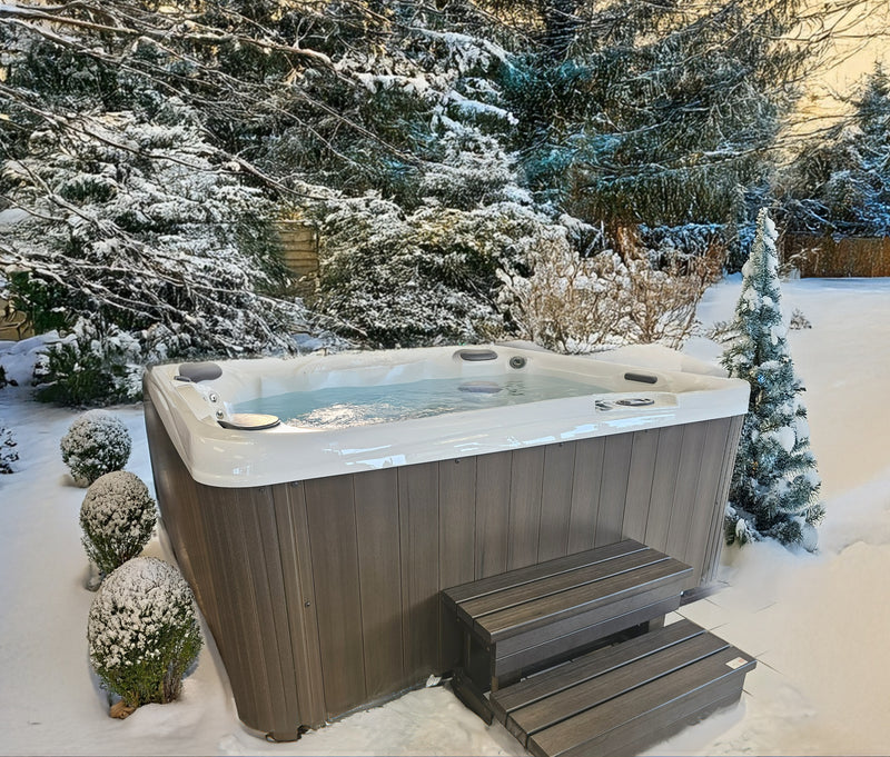This is a lifestyle image showing this specific hot tub in a snowy, Midwestern backyard.