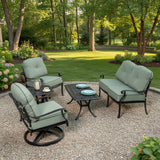 This is a lifestyle image showing this cushioned patio furniture set on a gravel patio in a grassy backyard on a sunny day.