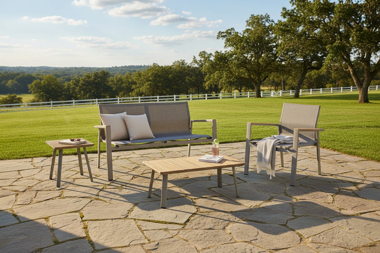 This is a lifestyle image showing this patio set on a stone patio in a grassy backyard on a sunny day.