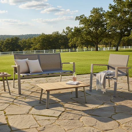This is a lifestyle image showing this patio set on a stone patio in a grassy backyard on a sunny day.