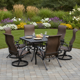 This is a lifestyle image showing this patio furniture set on a stone patio in a grassy yard on a sunny day.