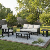 This is a lifestyle image showing the patio furniture set in a rock garden in the middle of a backyard.