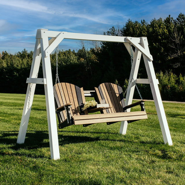This is a lifestyle image showing the white A-frame vinyl swing stand with an Antique Mahogany and Black colored bench.