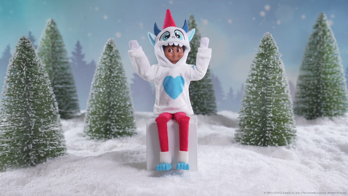 This video showcases a Scout Elf wearing the Yeti Monster hoodie and boots with small snow covered trees in the background.