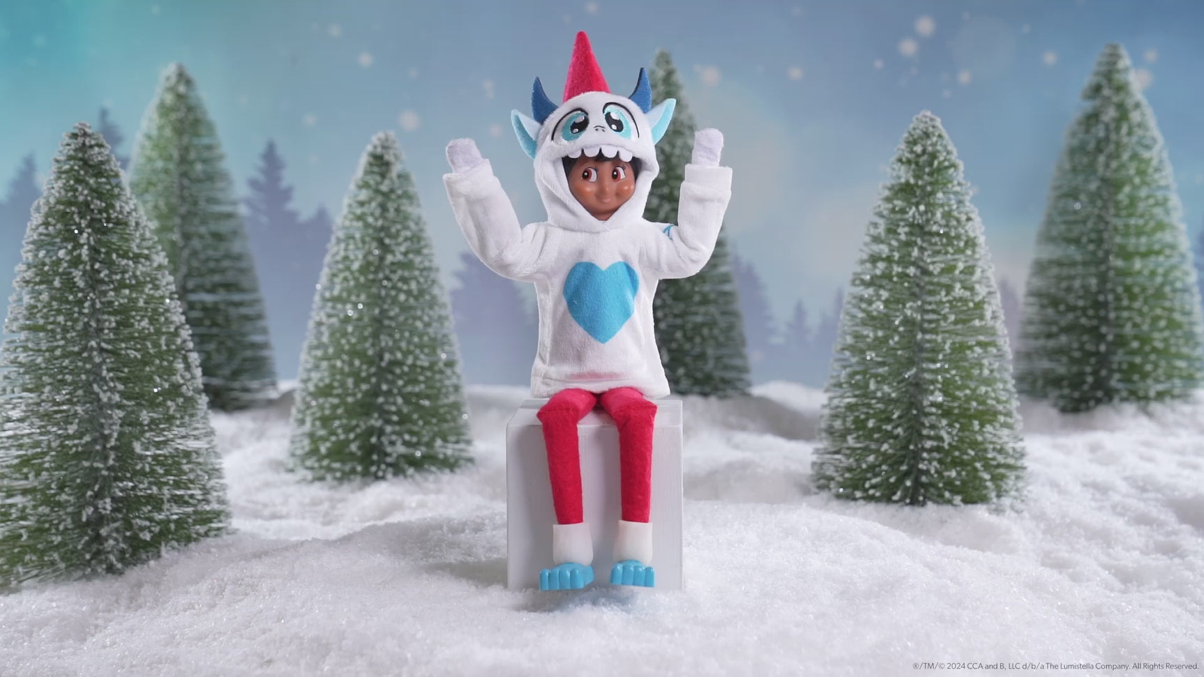 This video showcases a Scout Elf wearing the Yeti Monster hoodie and boots with small snow covered trees in the background.