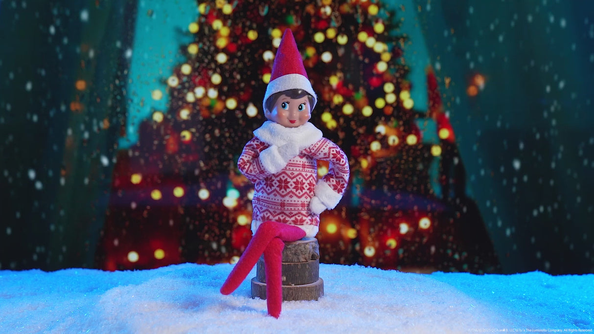 This video showcases the Elf on the Shelf Sweetie Dress with a decorated Christmas tree in the background.