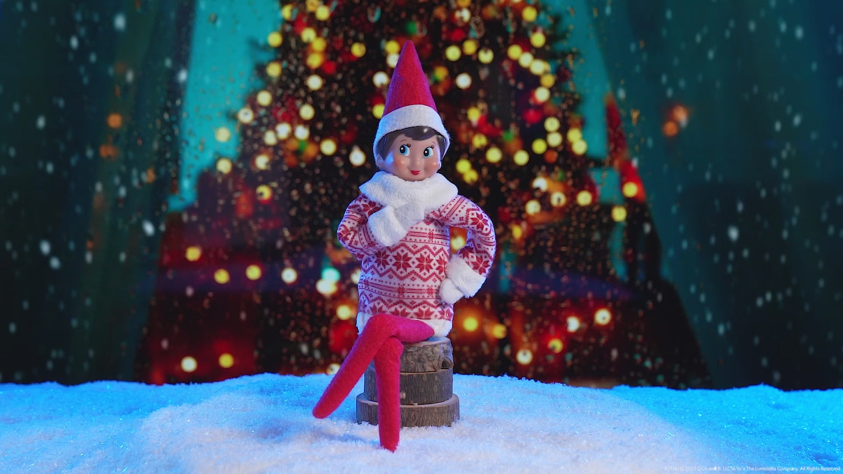 This video showcases the Elf on the Shelf Sweetie Dress with a decorated Christmas tree in the background.