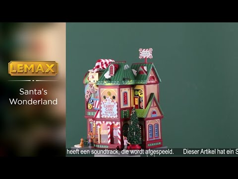 Polyresin building for a Lemax display. Designed to look like a very colorful candy store. The pipes on top are designed to look like candy canes. There are colorful gears visible and you can see presents rotating inside. There are kids looking at the candy and a girl admiring a decorated Christmas tree. There's also a dog wearing a Santa hat on the sidewalk.