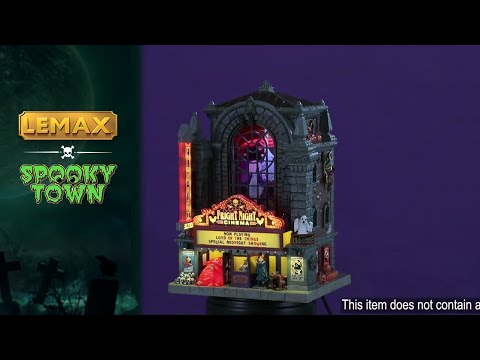 This is a video showing the details of the Lemax Spooky Town lighted building that's designed to look like a tall, gothic building that's been turned into a movie theater. It's called Fright Night Cinema. There are ghosts visible through the big window in the front. Underneath the marquee, there are skulls and a vampire standing next to a werewolf.