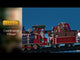 Plastic train on plastic tracks for a Lemax Village tabletop display. The train is Christmas themed