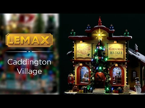 Resin lighted building for a Lemax display. Designed to look like a Christmas store. There are decorative ornaments on the roof, a large decorated Christmas tree over the front door, a nutcracker, presents and a snowman on the sidewalk.