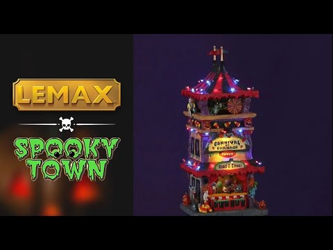 Polyresin lighted building for a Lemax display. Designed to look like a tall, carnival tower with a red and black striped tarp on top. There are jack-o-lantern, skull and candy corn accents. The bottom of the tower has a sign that reads "SHOOT A CLOWN!" and has a little booth with prizes and balloons.