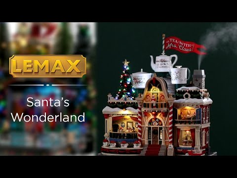 Resin lighted building for a Lemax display. Designed to look like building decorated for Christmas. There are three large mug statues on the roof and a large red flag that reads "TEA WITH MRS. CLAUS."